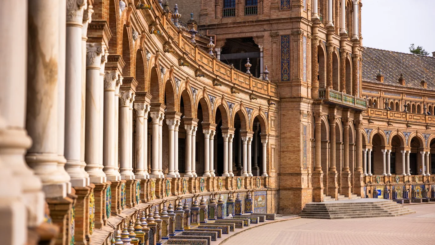 Sunlit arches and ceramic balustrades at Plaza de España in Seville