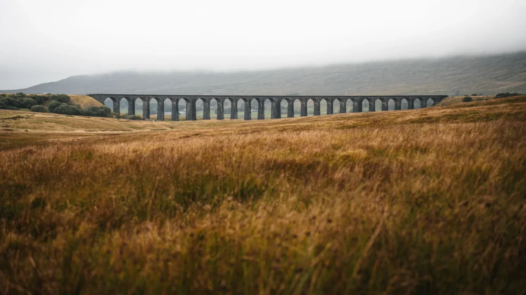 Illustrative stock image of a long stone railway viaduct across open moorland beneath low cloud.