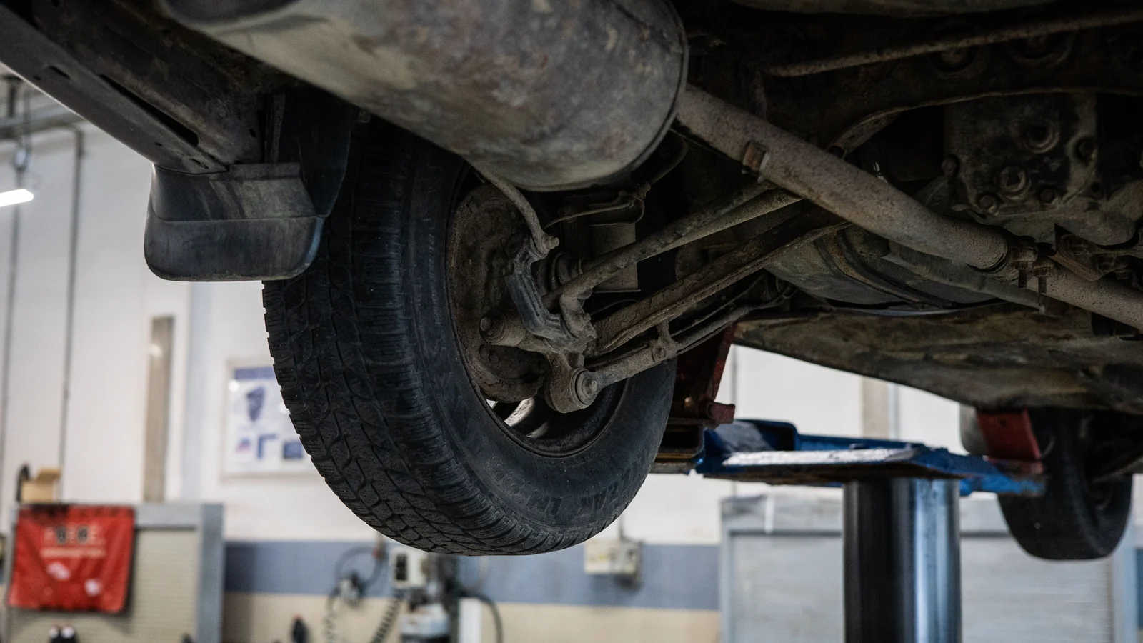 Illustrative stock image of a raised car’s wheel and underbody components.