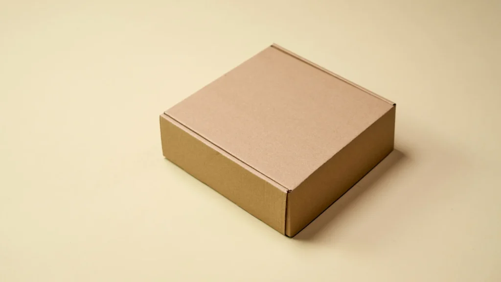 A closed brown cardboard box on a pale surface.